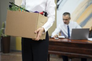 Mujer despedida con una caja en la mano llena de sus pertenencias